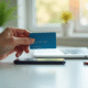 Main tenant une carte bancaire au-dessus d'un smartphone avec message d'annulation